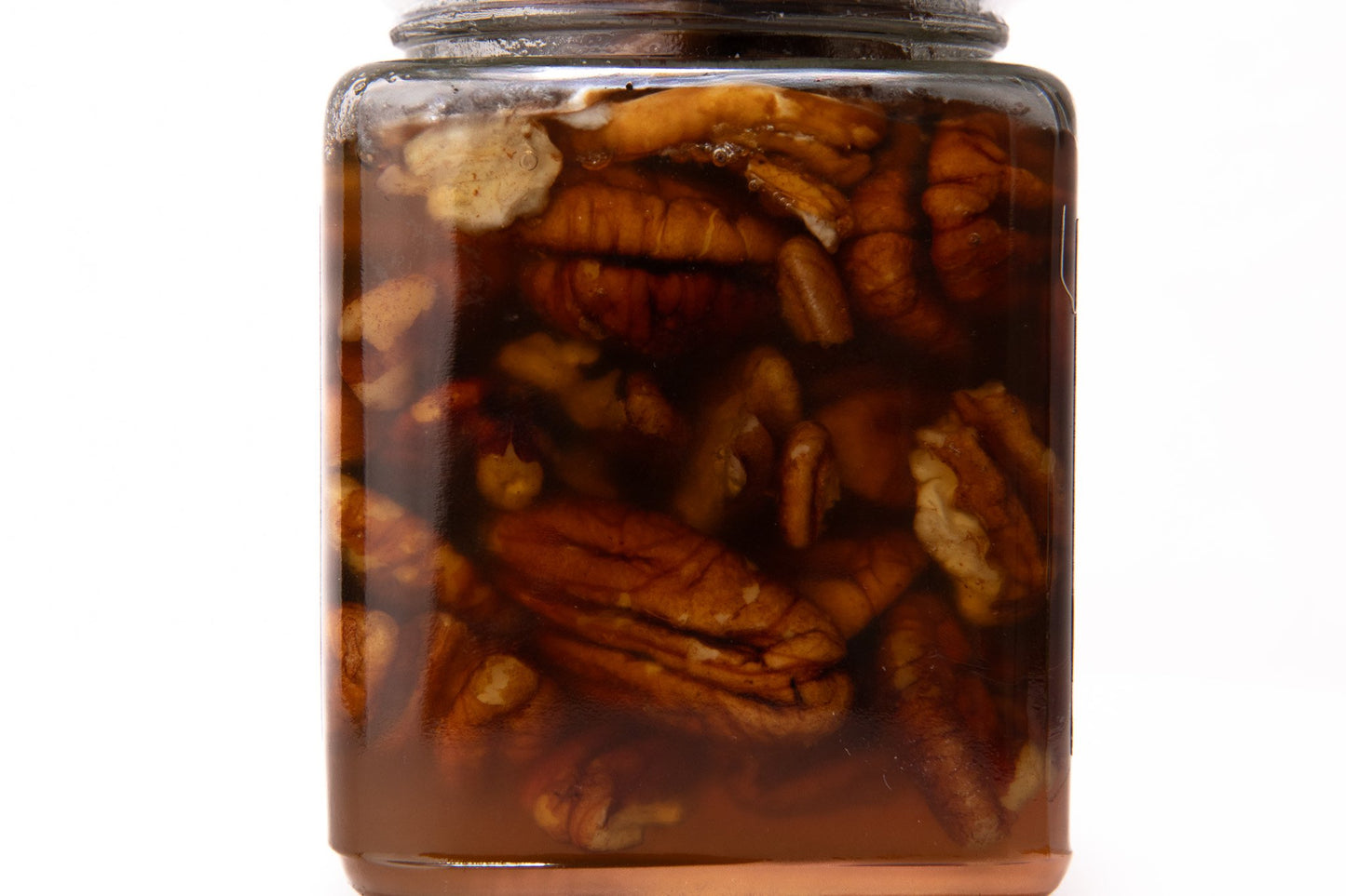 Close-up of pecan pieces in golden raw honey